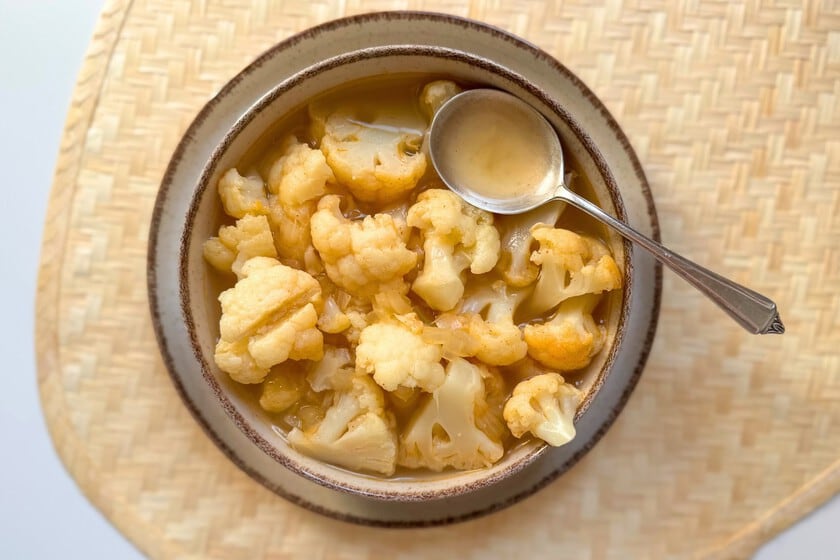 La sopa de coliflor en trozos vuelve al primer plano: cuerpo, cuchara y quinze minutos de cocción